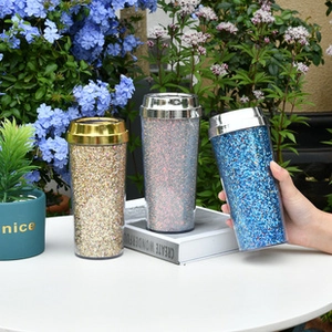 Close-up of double-walled acrylic coffee cups with glitter sequins and metallic lids