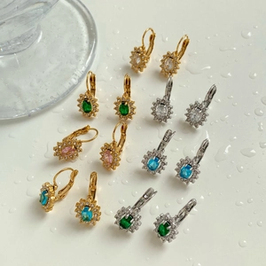 Détails rapprochés de boucles d'oreilles tournesol en zircon plaqué or et argent