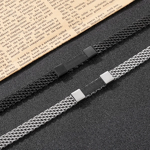 Detail der gewebten Metallarmbänder in Schwarz und Silber mit Gliederstruktur und Verschluss