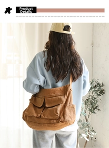 Brown canvas messenger bag detail showing large capacity and multi-pocket design on model