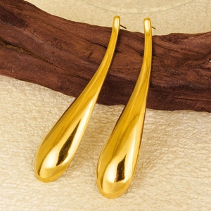 Macro detail of high-polished 304 stainless steel gold drop earrings on wooden base