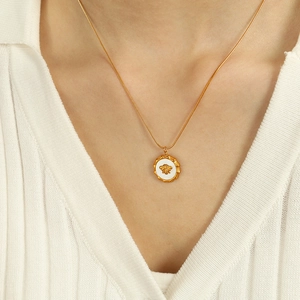 Collana minimalista con ciondolo ape dorata su una raffinata catena serpente da donna