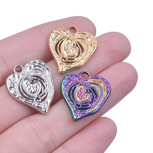 Detailed close-up of heart-shaped hollow pendants in gold, silver, and rainbow steel