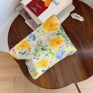 Detailed view of floral cotton makeup bag with yellow flowers on a dark wood table