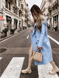 Close-up of double-breasted light blue wool coat with classic lapels and side pockets