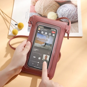 Pink crossbody phone wallet with clear touchscreen window and faux leather finish