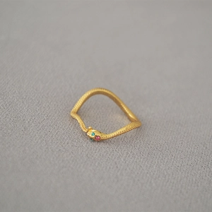 Close-up of golden snake ring with textured scales and sparkling zircon eyes detail