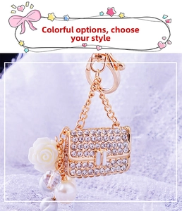 Detailed view of luxury handbag keychain with rhinestones, pearls and rose charms