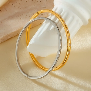 Detail of elegant gold and silver stainless steel bangles with sparkling zircon inlay