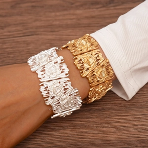 Macro detail of gold and silver hollow flower bracelets with matte metallic texture