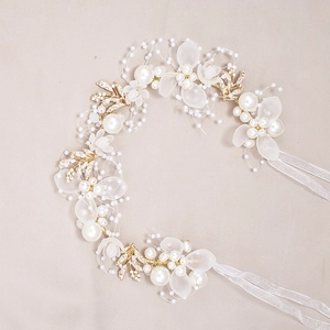 Detail of bridal headband with gold wire, white frosted flowers, pearls, and rhinestones