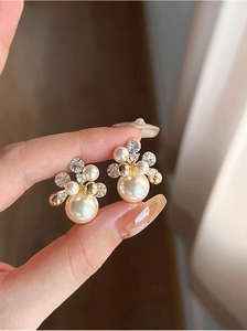 Gros plan détaillé de boucles d'oreilles fleur dorées 18k avec perles et zircons
