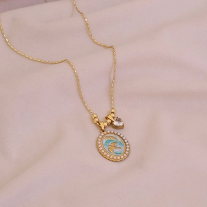 Gold beaded necklace with oval swallow enamel pendant and small heart zircon charm
