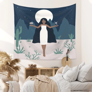 Artistic bohemian tapestry showing a woman in a desert scene hung over a bed
