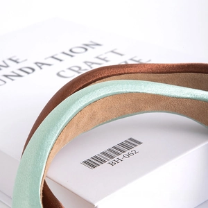 Close-up of premium satin headbands in mint and bronze with anti-slip inner lining