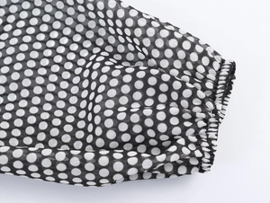 Close-up detail of elastic lantern sleeve cuffs on a black white polka dot chiffon dress