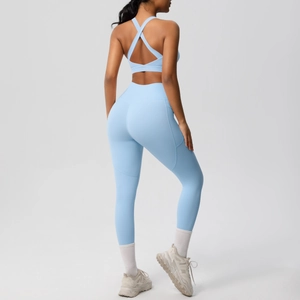 Detail of high-waist light blue yoga leggings with side pockets and cross-back sports bra