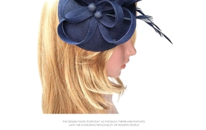 Detail of navy blue fascinator hat with mesh net and delicate feathers for weddings