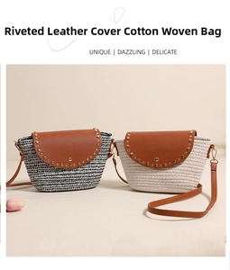 Close-up of woven straw bags with brown leather flap and decorative gold rivets