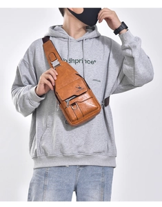 Detail view of the vintage brown waterproof chest bag with adjustable strap and textured finish