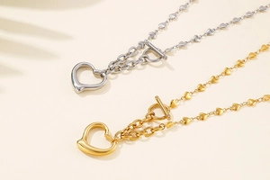 Detailed view of gold and silver heart link necklaces with T-bar toggle clasp closure