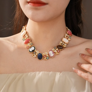 Detailed view of a vintage cameo necklace with colorful gemstone portraits and floral accents