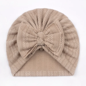 Detail of soft ribbed knit baby turban hat with oversized bow in beige color