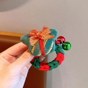 Gros plan d'un chouchou de Noël avec nœuds festifs rouge vert et clochettes dorées