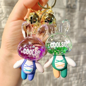 Detail of purple and green acrylic quicksand bunny keychains with glitter and gold bells