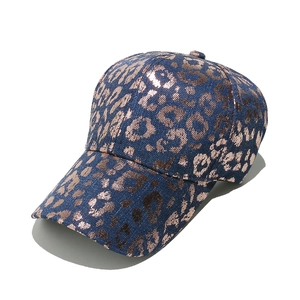 Detail of navy blue baseball cap featuring metallic rose gold leopard print texture