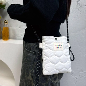 Quilted white crossbody bag with braided rope strap shown on model for a modern look