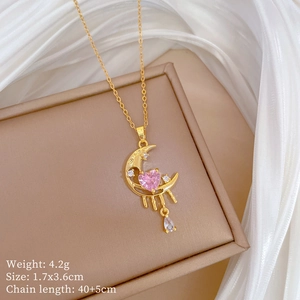 Detail of gold moon necklace with pink heart gem and water drop pendant on silk
