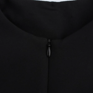Detail of a black professional top featuring a hidden back zipper and textured fabric