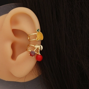 Cute fruit-shaped ear clips with banana and cherry designs on a model ear