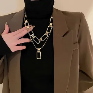 Minimalist double-layered gold chain necklace featuring bold links and a sleek rectangle pendant