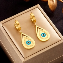 Macro detail of teardrop hollow evil eye earrings on a premium gold jewelry box