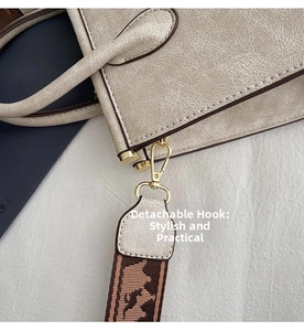 Detail of detachable hook and textured leather shoulder bag with vintage jacquard strap