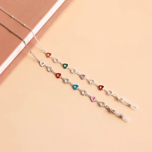 Detail of colorful enamel heart charms on a silver eyewear chain and face mask holder
