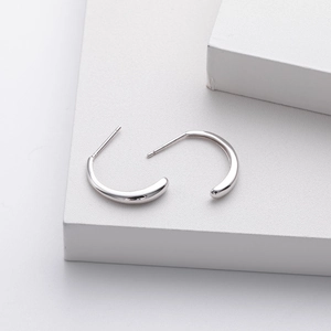 Macro shot of silver S925 petal hoop earrings on white geometric stands