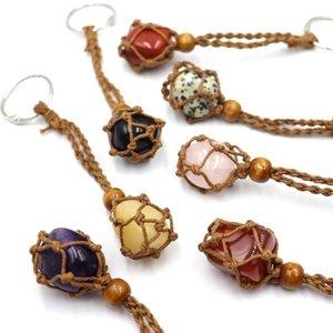 Detailed view of handmade woven mesh keychains with various natural raw crystal stones