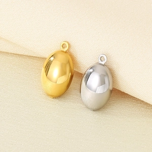 Polished hollow oval pendants in 18K gold and silver finishes on a textured fabric base