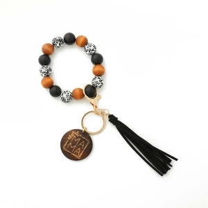 Detail of leopard print wood beads, black tassel, and MAMA engraved charm on keychain