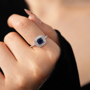 Detailed shot of a geometric blue sapphire ring with double halo pavé zircon setting