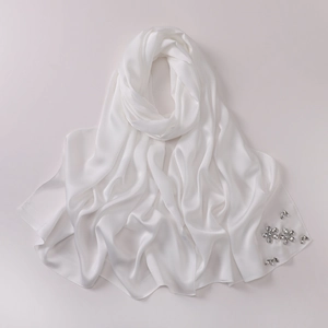 Detail of white satin hijab featuring elegant hand-set rhinestone flower embellishments