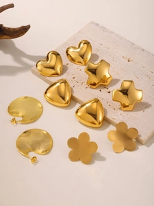Détail macro de boucles d'oreilles géométriques plaquées or 18 carats sur socle en pierre