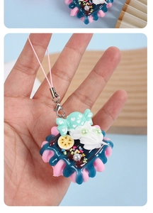 Close-up of realistic strawberry cream cake keychain with colorful resin decorations