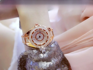 Close-up of gold-tone women's watch featuring a full diamond-encrusted bezel and band