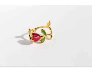 Macro detail of French style rose ring with deep red enamel petals and green leaves