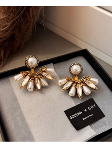 Détail de boucles d'oreilles vintage en forme d'éventail avec perles et cristaux