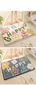 Close-up of highly absorbent anti-slip bathroom mats with Happy text and floral design